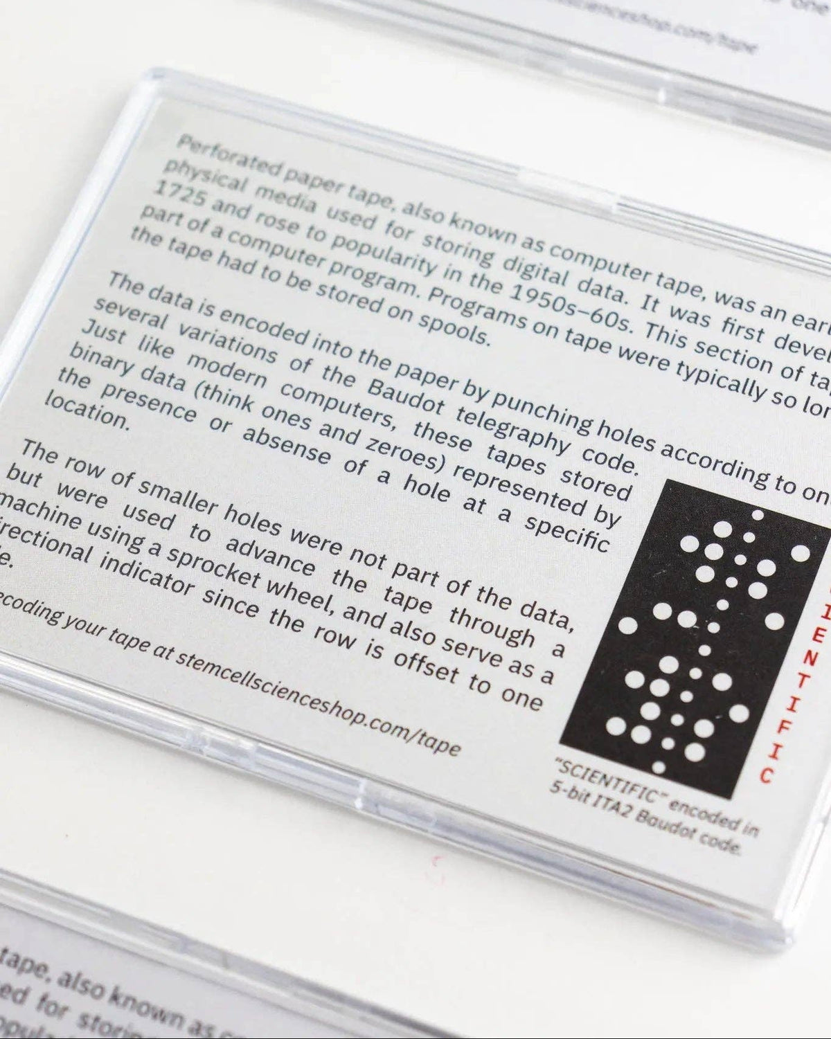 Close-up of a perforated paper tape with text and a label on a white background