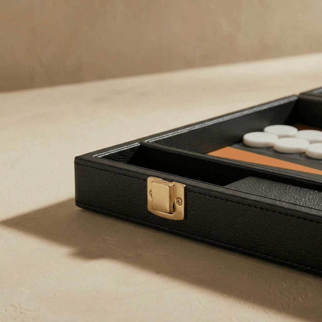 Black leather case with gold clasp on a beige surface