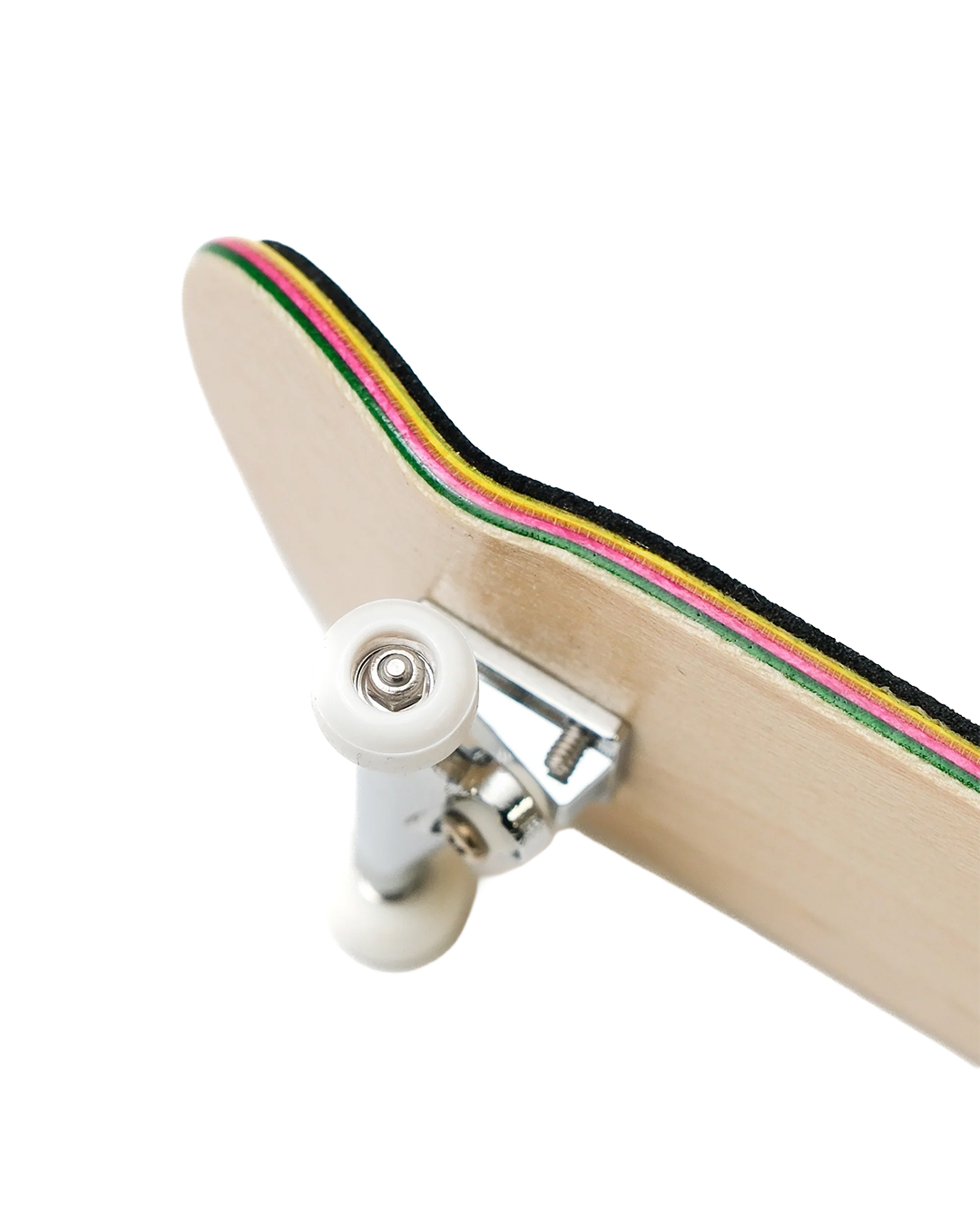 Close-up of a skateboard deck showing the underside, with a light natural wood base, white wheels, and a multicolor striped edge in black, green, yellow, pink, and red on a white background.