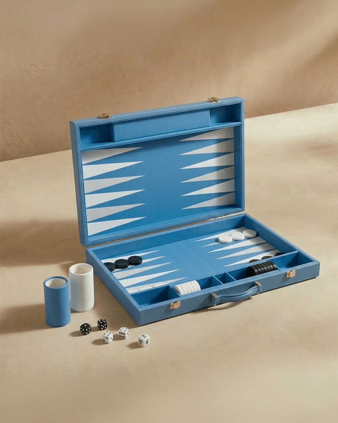 Blue backgammon set with pieces and dice on a beige surface