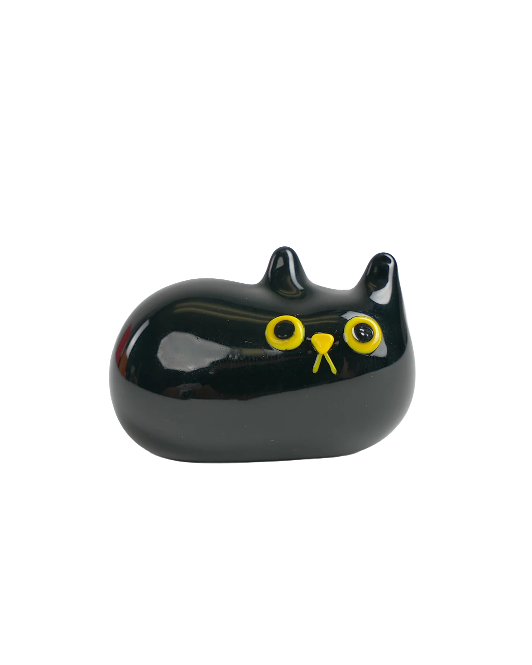 A glossy black cat-shaped object with yellow eyes and a yellow nose, photographed on a plain white background.