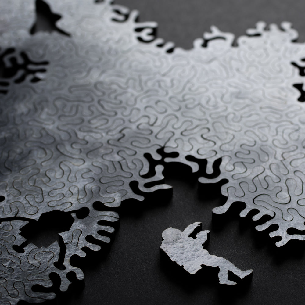 Close-up of a puzzle with one piece missing, revealing a black and white illustration underneath.