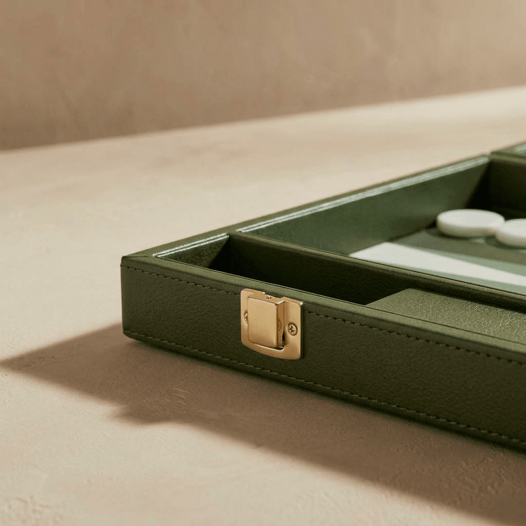 Green jewelry box with a gold clasp on a beige surface