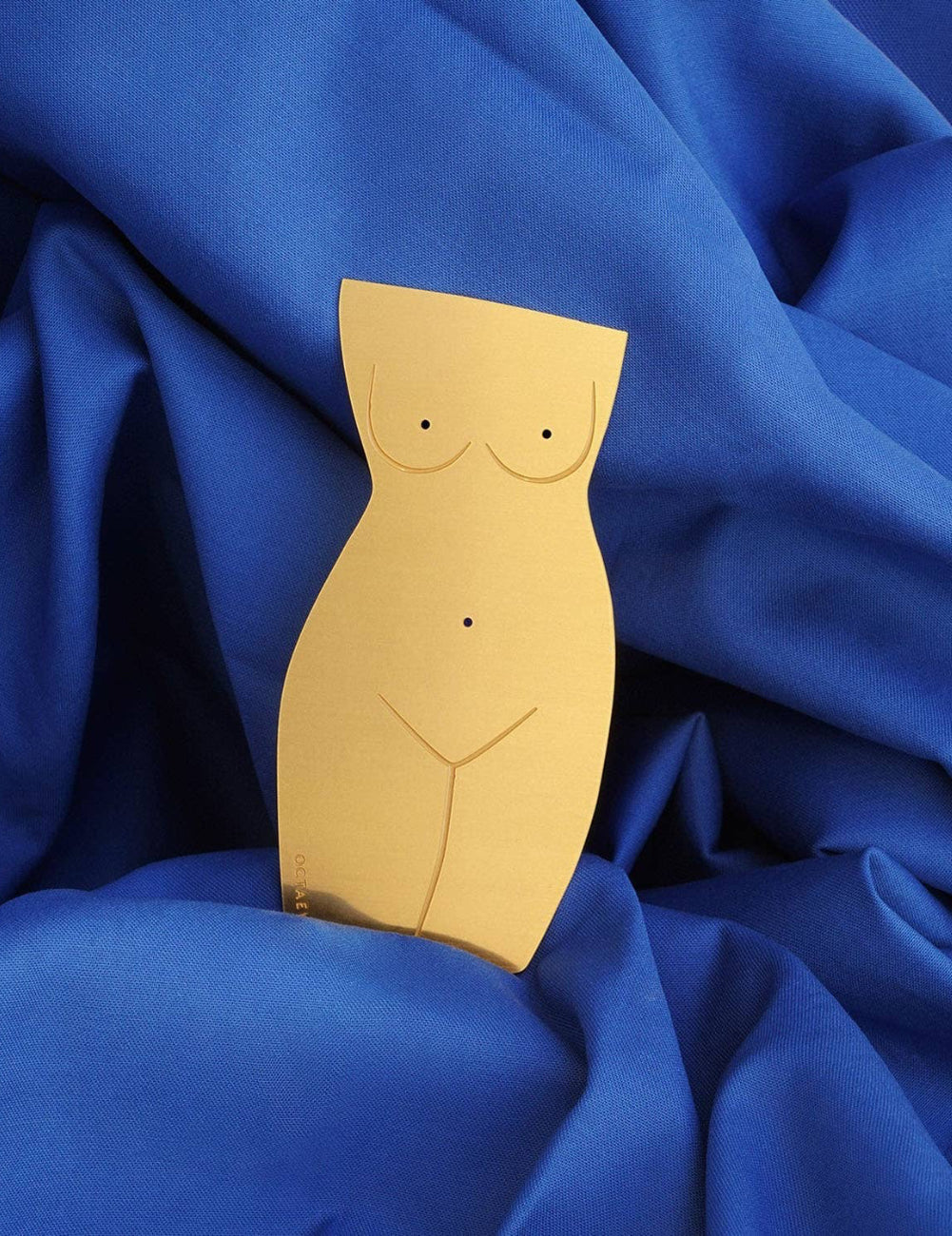 Gold bust-shaped object on a blue fabric background