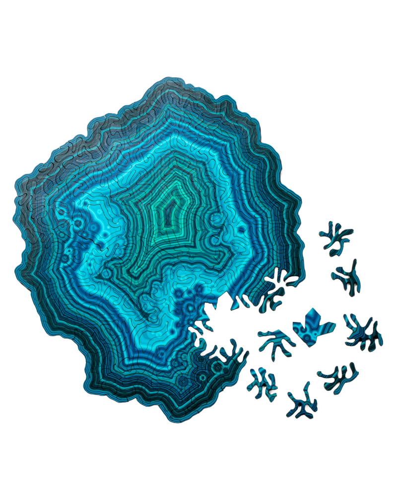 A decorative jigsaw puzzle featuring an agate slice design in layered shades of teal, turquoise, and blue, with small matching blue crystal-like puzzle pieces scattered along the lower right edge, shown on a plain white background.