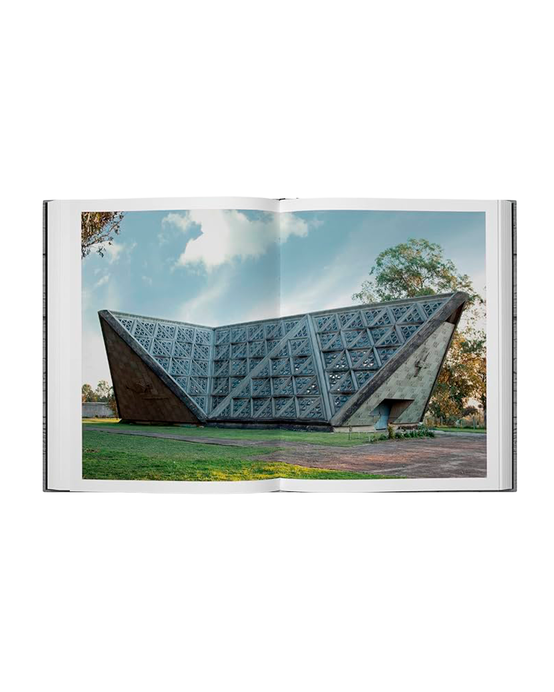 An open book or magazine spread showing a photograph of a modern angular concrete structure outdoors under a blue sky, photographed against a light gray background.