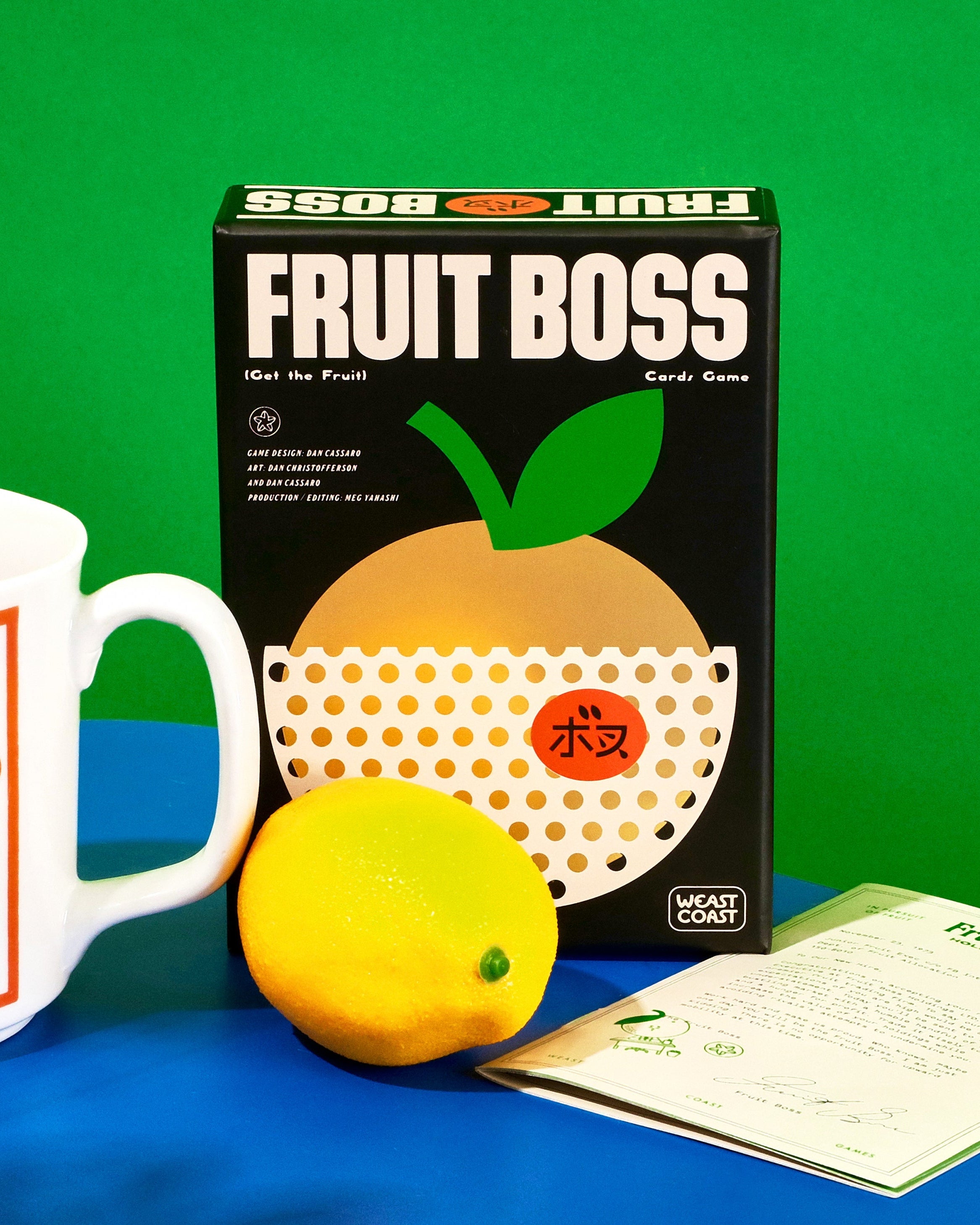 Fruit Boss game box with a mug labeled 'The Boss' and a lemon on a blue surface against a green background.
