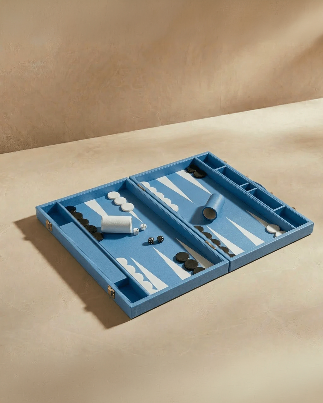 Backgammon set with pieces on a beige surface