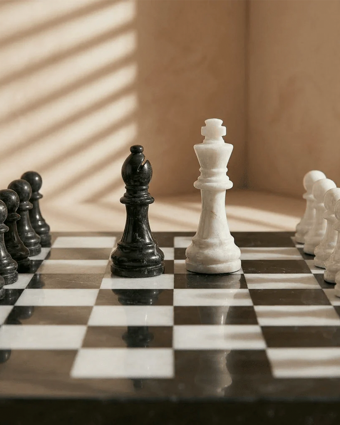 Close-up of a chessboard with black and white pieces on a checkered surface.