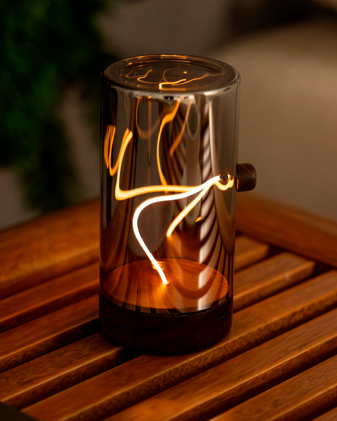 Decorative lamp with glowing interior on a wooden surface