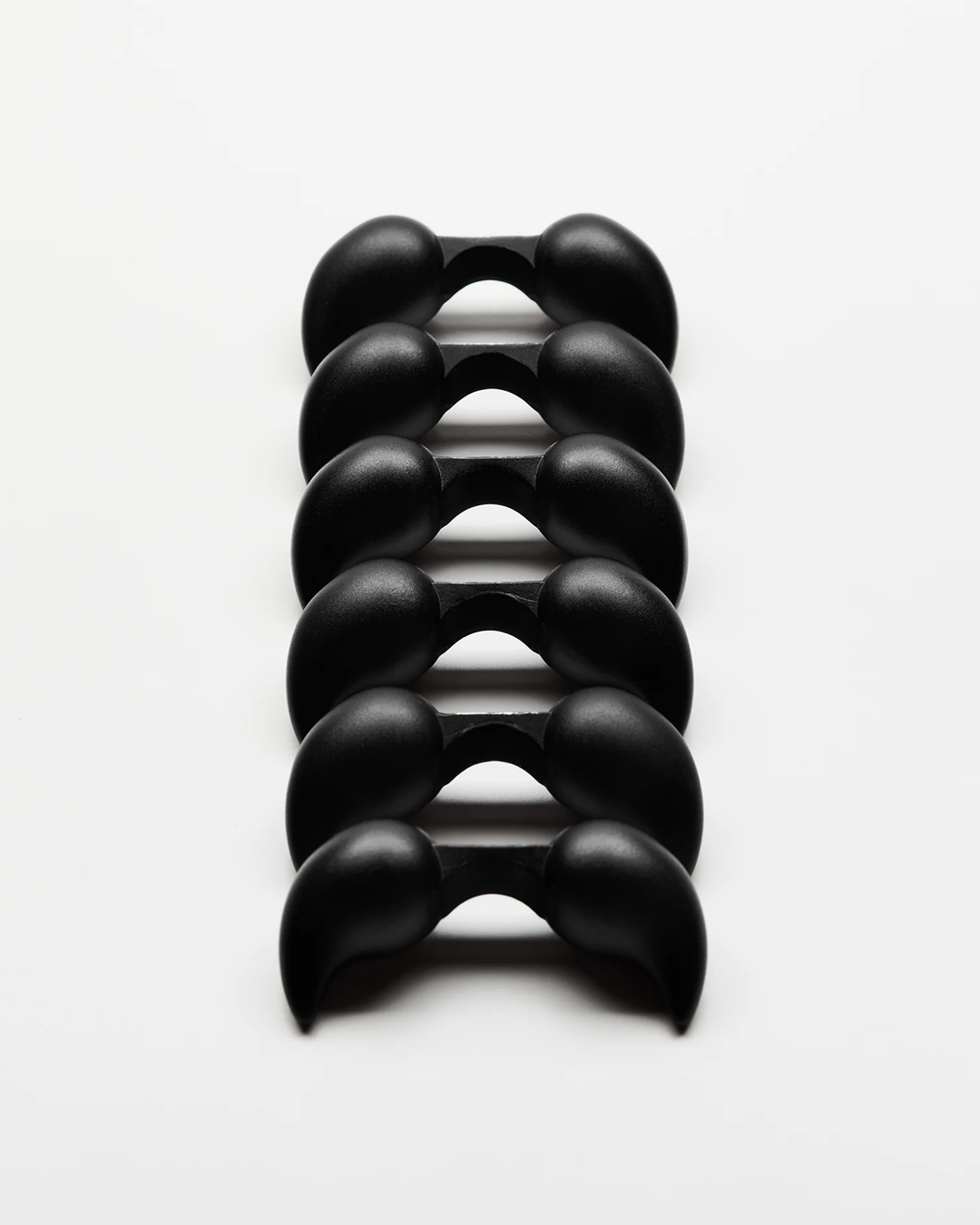Stack of black massage rollers on a white background