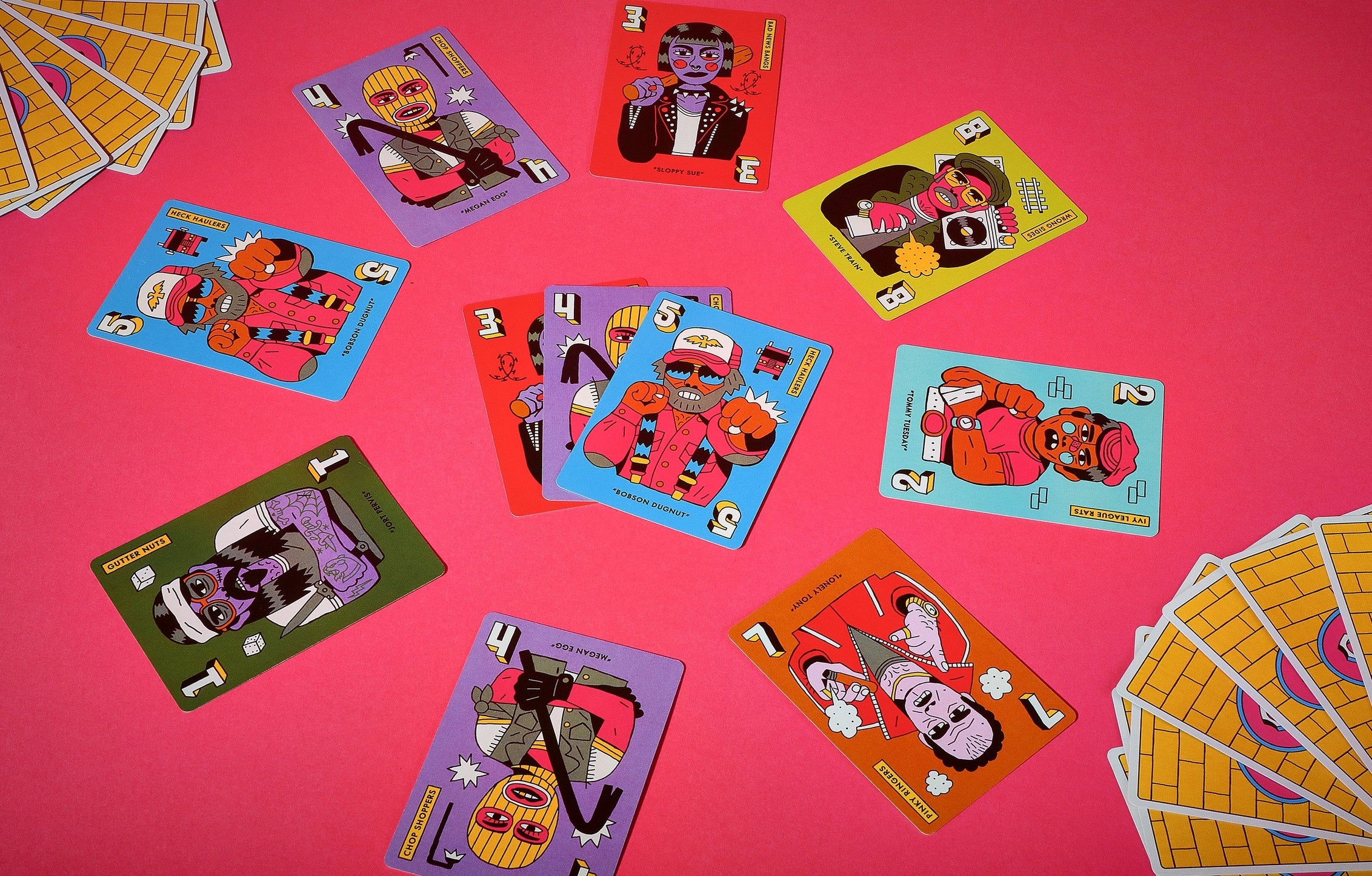 Colorful playing cards with cartoon characters on a pink background