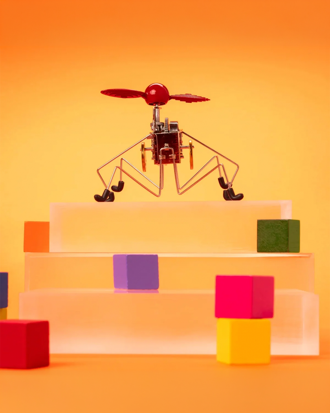 a geometric-centered photo of some stairs with a bug-looking wind-up toy on the top.