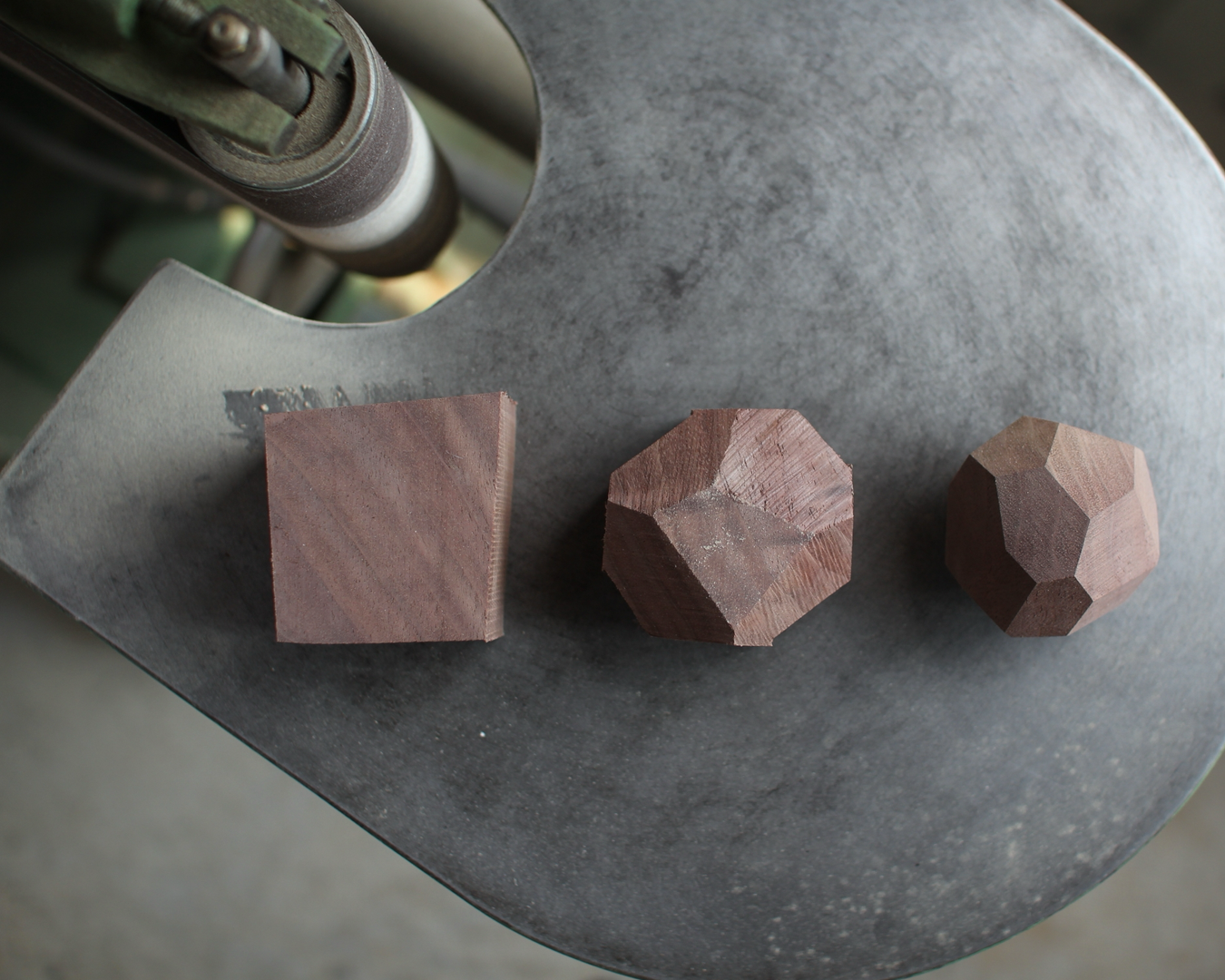 Three wooden blocks of different shapes on a metal surface